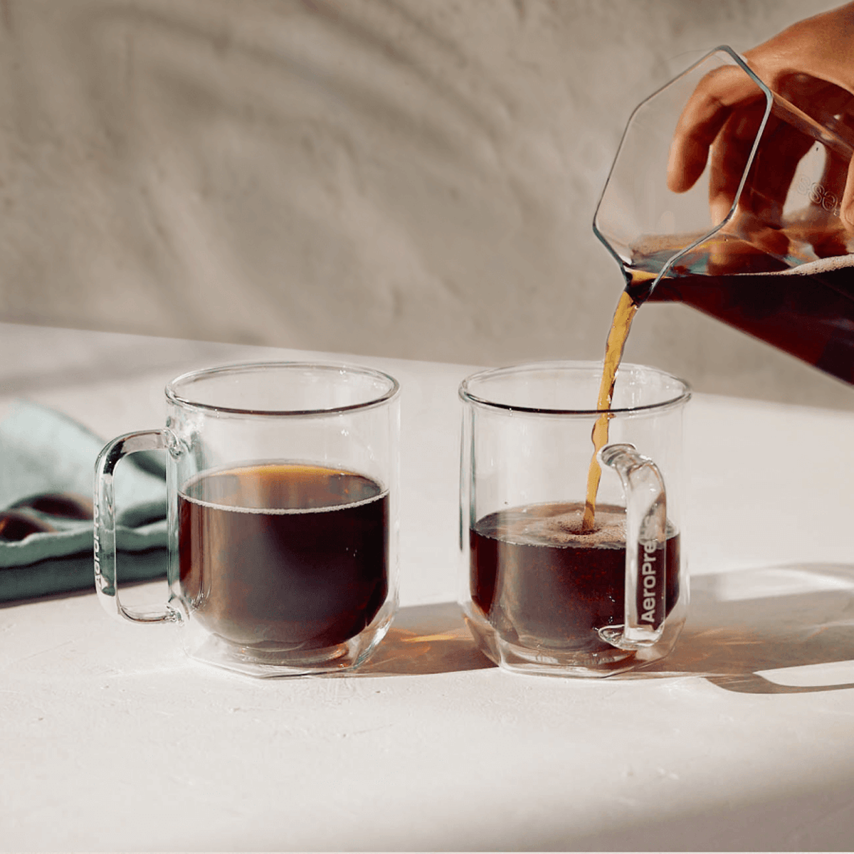 AeroPress® XL Karaffe beim Ausschenken in zwei Tassen - rhiinland.com