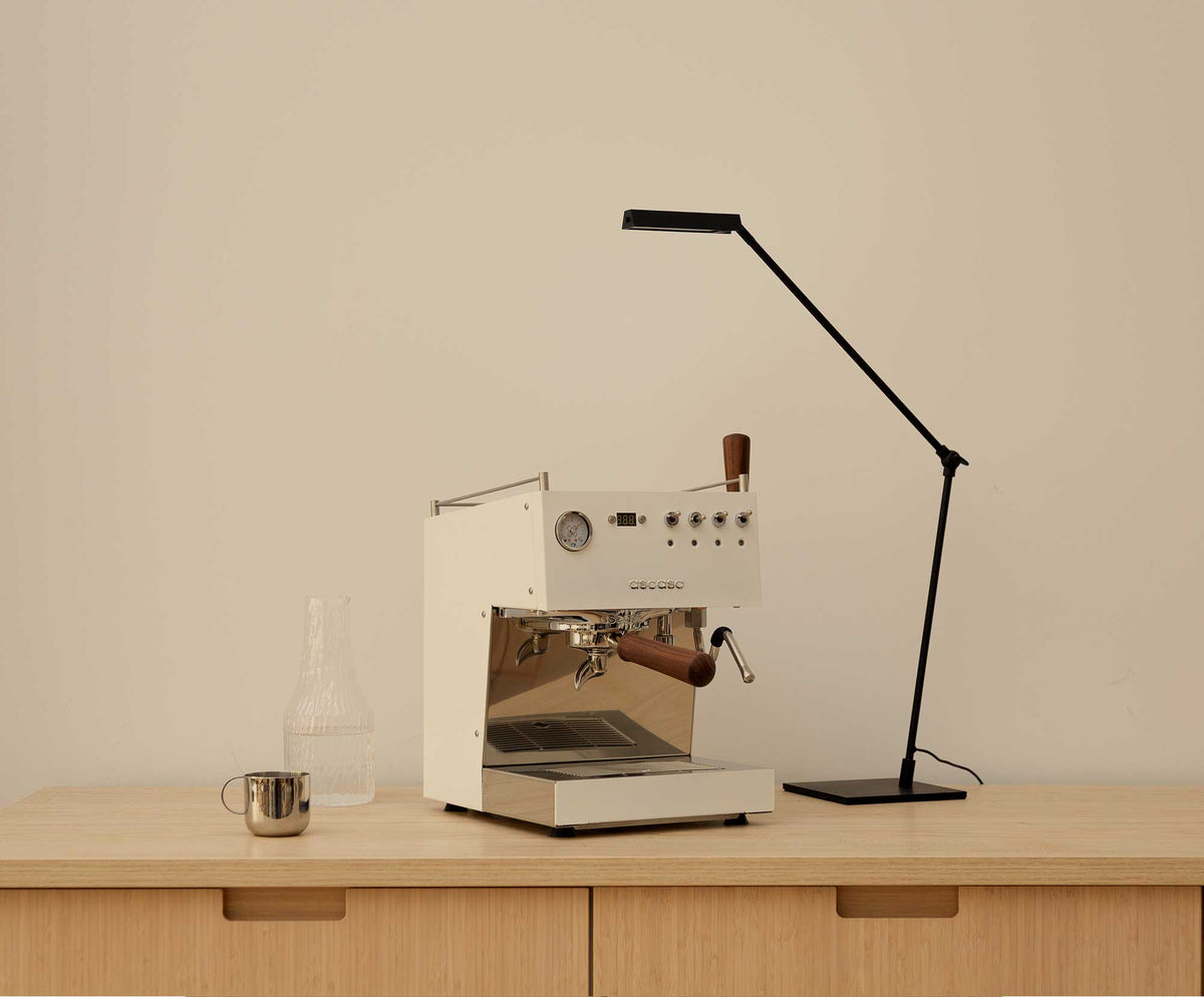 Ascaso Steel in Weiß auf einem Holz-Sideboard mit Lampe und Karaffe